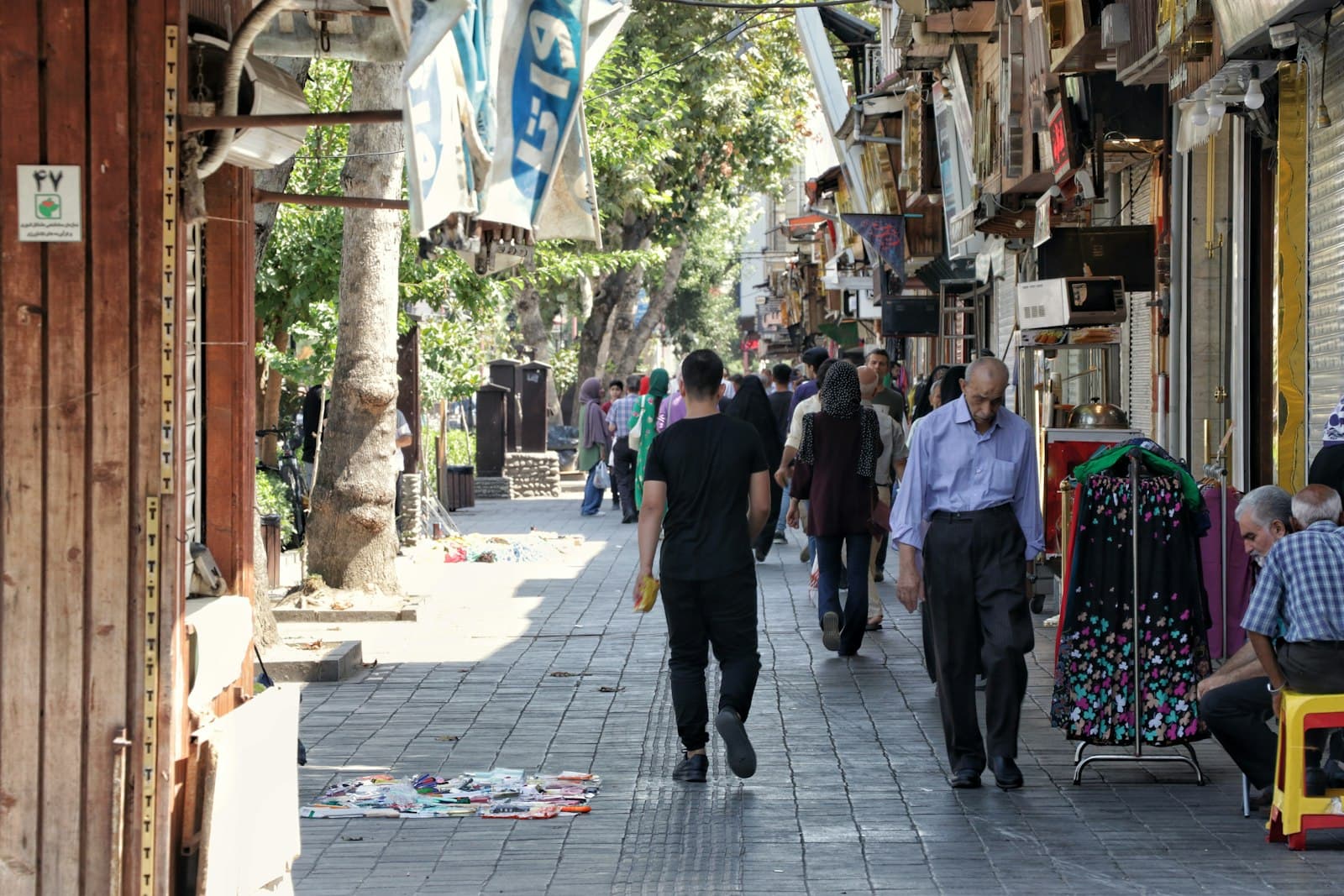 People walking down a street lined with small shops